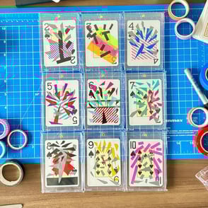 foto de cima mostrando nove das 55 cartas da série arte de bolso.