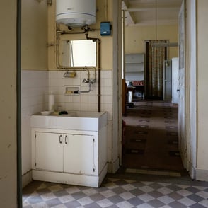 Evier et chauffe eau dans une pièce vétuste