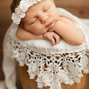 bébé qui dort dans sceau avec un joli bandeau de fleurs