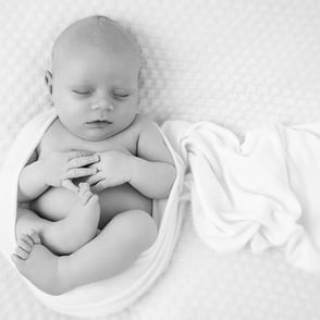 photo en noir et blanc de bébé enroulé d'un wrap en rond