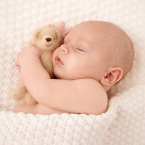 bébé qui dort avec un joli petit ourson