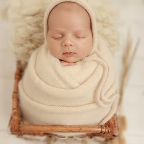 bébé tendrement enveloppé dans un wrap de laine claire