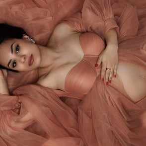 séance photo maternité femme couchée au col dans une robe de tulle