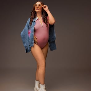 photographie de grossesse en mode style avec une veste en jean et un body rose