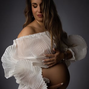 photo de profil de grossesse dans un haut plissé blanc sur fond noir