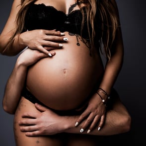 photo de grossesse dont les mains du papa entourent le ventre de la maman