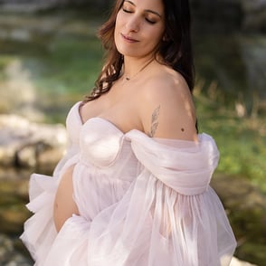 Séance photo grossesse en extérieur avec une robe de tulle rose claire pour beaucoup de douceur