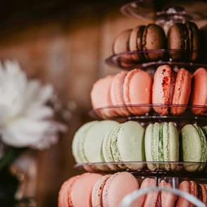 A close-up of a tiered stand filled with colorful macarons .