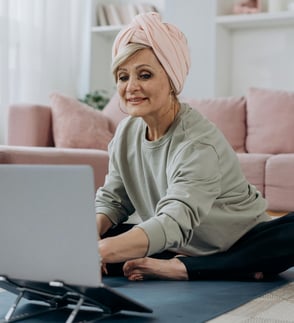 Mujer adulta mayor en tapete de yoga participando en clase online de bienestar de Yarkeey