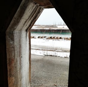 a window with a view of a train passing by. Waterbody through a frame