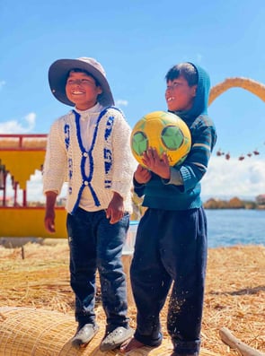 Portrait of two Peruvian children playing with a ball on the Uros Islands, Lake Titicaca.