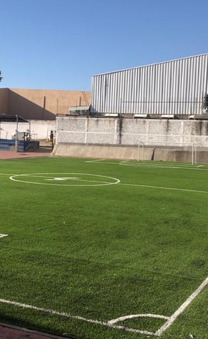cancha de pasto sintetico de futbol dentro de una universidad