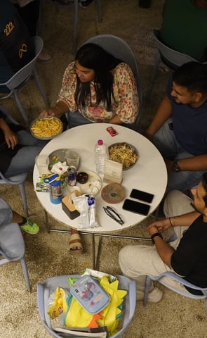 a group of people sitting around a table at basil the otherside