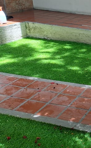 Pasto sintético verde y duradero instalado en un patio trasero