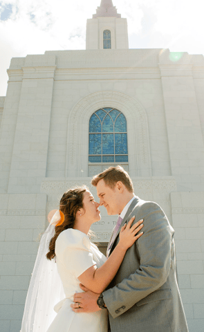 a bride and groom standing in front of a church