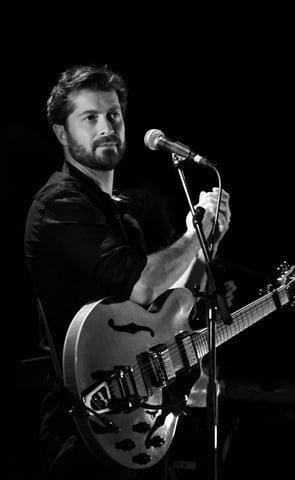 a man with a guitar and microphone