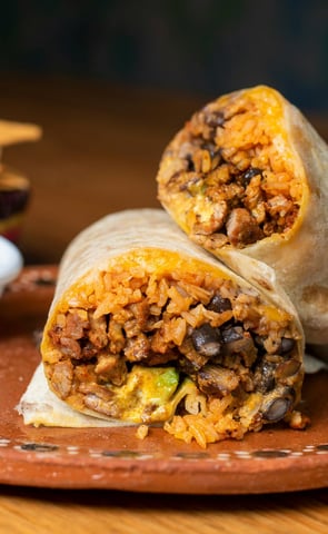 Burritos filled with ingredients, resting neatly on top of one another.