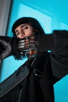 Futuristic woman dressed in black with slightly distorted body and a forearm that appears cybernetic