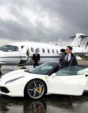 a man in a suit and tie standing next to a white car