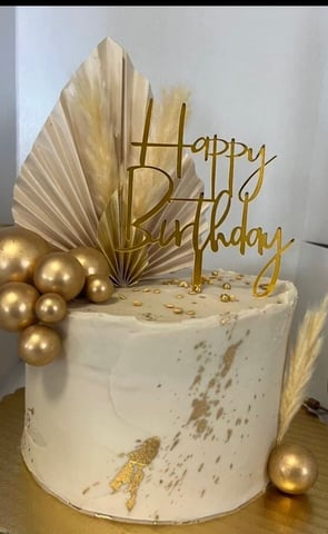 a cake with a gold birthday cake topper