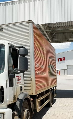Caminhão branco com identidade visual aplicada, representando branding para TBR