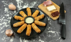 Des tequeños dans une assiette avec une sauce et des ingrédients