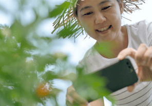 Woman taking photos of her plants to share with Pluck for help