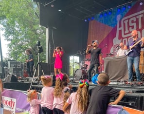 LuxeBand performing at an outdoor festival for an audience of children