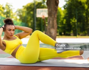 a woman doing a cruncher on a basketball court