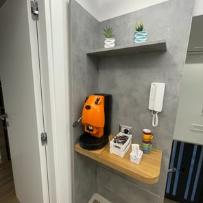 Cucina attrezzata con frigorifero, microonde, stoviglie e angolo coffee corner