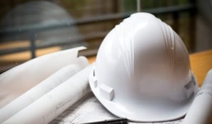 Construction hardhat and building drawings