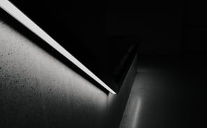 a black and white photo of a stair railing with a light
