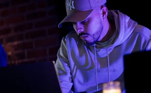 a man in a white hoodie and a white hat is sitting at a table