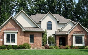 alt="Brick house with painted trim and siding"