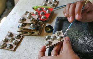 a person is using a pair of scissors to cut a button