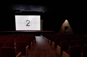 Coded Black gameplay screenshot showing a dark movie theatre with the film about to start.