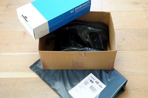 a box of shoes is sitting on a box with returns envelope and foot impression box
