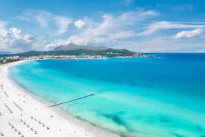 Scenic view of Alcudia Bay on a clear day, popular boat tour destination in Mallorca