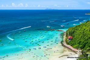 a beach with boats and people on the water