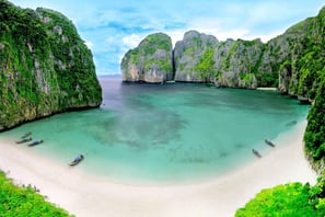 a beach with boats and corals in the water