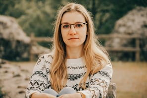 a woman with glasses and a sweater on