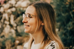 a woman with glasses and a white sweater