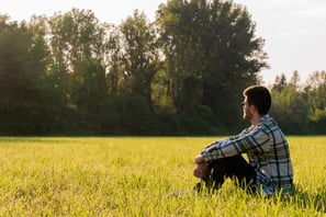 a man sitting in a field 