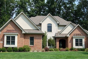 alt="Brick house with painted trim and siding"
