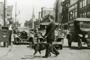 a man in a suit and tie is walking with a service dog