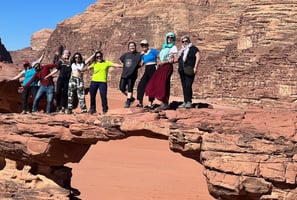 a group of people standing on a rock formation