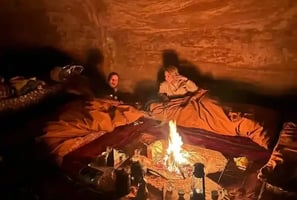 a man and woman sitting in a cave like setting