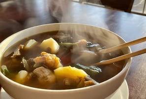 a bowl of bouillon soup with chopsticks and chopsticks