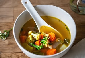 a bowl of broth  soup with a spoon and a spoon in it