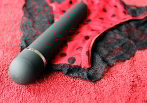 a vibrator and panties on red canvas